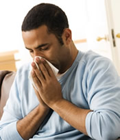 Image of man sick with flu blowing his nose